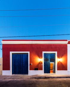 a red and white building with two blue doors