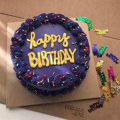 a birthday cake with the words happy birthday written on it, surrounded by confetti and sprinkles