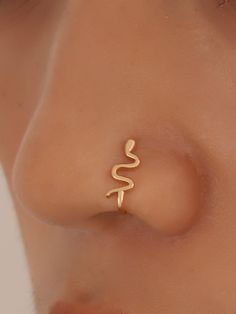 a woman's nose with the word snake on it, and an ear piercing