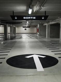 an empty parking garage with arrows pointing to the left