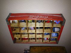 an old coca - cola cooler is hanging on the wall