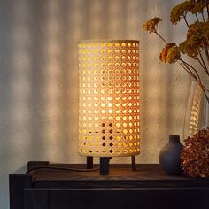 a lamp that is sitting on a table next to vases with flowers in them