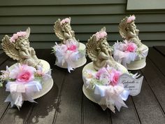 three small cupcakes with angel figurines on them sitting on a table