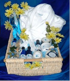 a wicker basket filled with personal care items and flowers on a blue cloth background