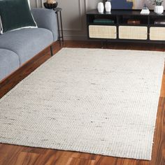 a living room scene with focus on the area rugs and the couch in the background