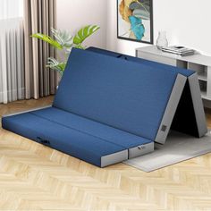 a blue couch sitting on top of a wooden floor