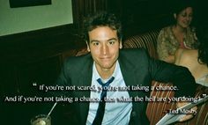 a man in a suit and tie sitting at a table with a glass of wine