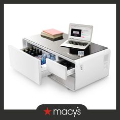 an open laptop computer sitting on top of a white desk with drawers and shelves underneath it