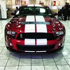 a red and white mustang in a showroom