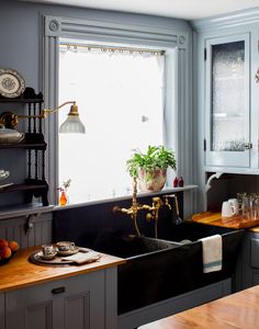 a kitchen filled with lots of counter top space and wooden counters topped with pots and pans