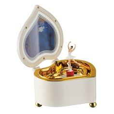 a white and gold musical box with a figure on top