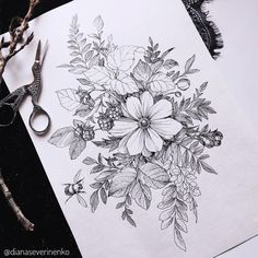 a drawing of flowers on paper next to scissors and some branches with leaves in it