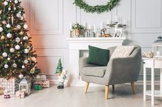 a living room decorated for christmas with a tree and presents on the floor in front of it