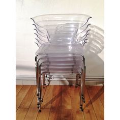 a stack of plastic chairs sitting on top of a hard wood floor