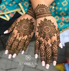 two hands with henna tattoos on them, one is showing off the intricate design