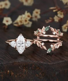 three different types of wedding rings on top of a wooden table with flowers in the background