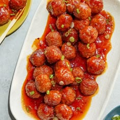 meatballs with sauce and green onions on a plate