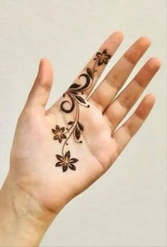 a woman's hand with hendix on it and flowers painted on the palm