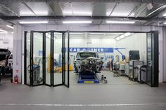 the inside of a car repair shop with cars in it