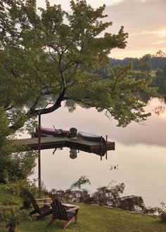 there is a boat tied to the dock by the water's edge at sunset