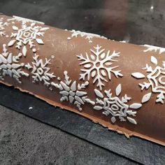 a piece of chocolate with white snowflakes on it is sitting on a table