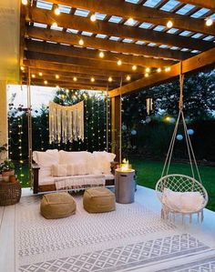 an outdoor living area with white furniture and string lights