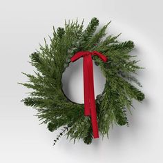 a christmas wreath with a red ribbon hanging from it