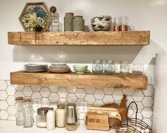 two wooden shelves filled with dishes on top of a white counter next to a tiled backsplash