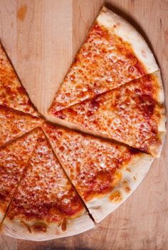 a sliced pizza sitting on top of a wooden cutting board