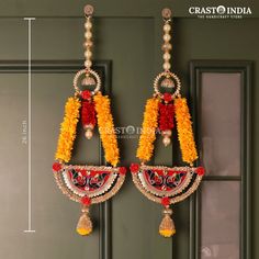 the earrings are decorated with flowers and beads on display in front of a green door