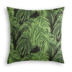 a green and black pillow with palm leaves on it