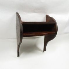 a small wooden shelf sitting on top of a white surface