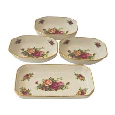 four white dishes with pink flowers on them