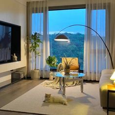 a living room filled with furniture and a flat screen tv mounted on the wall next to a window