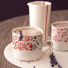 two mugs are sitting on a plate with lavender sprinkles in them