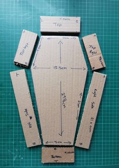 several cardboard pieces are laid out on top of a cutting board with measurements for each piece