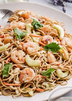 a white plate topped with noodles and shrimp