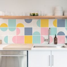 a kitchen with colorful tiles on the backsplash