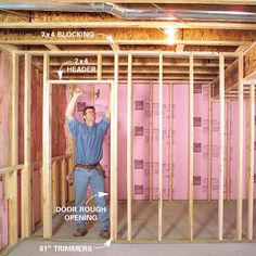 a man standing in the middle of a room with framing around his body and holding a hammer