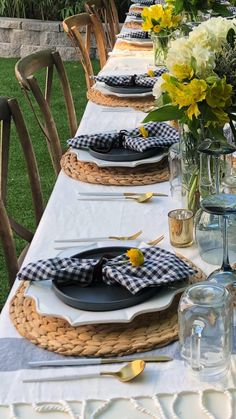 a long table with place settings and flowers in vases