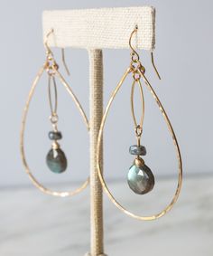 Meet one of our new favorites of the season, the Brie Marquis Drop Earrings. Faceted Moonstone briolettes with flashy blue undertones are suspended within hand forged teardrops for a look that is as easy for the office as it is a night out. All gold elements are made from high quality 14k Gold Fill that will not flake, wear off or discolor over time. MATERIALS Moonstone Gemstones | 14k Gold Fill ear wires and frame MEASUREMENTS2.25" drop from ear | 1.4" width ORIGIN Handcrafted in Florida STYLEB Beaded Chandelier Earrings, Bijoux Fil Aluminium, Hammered Hoop Earrings, Wire Jewelry Designs, Labradorite Earrings, Beaded Earrings Patterns, Beaded Chandelier, Wire Work Jewelry, Homemade Jewelry