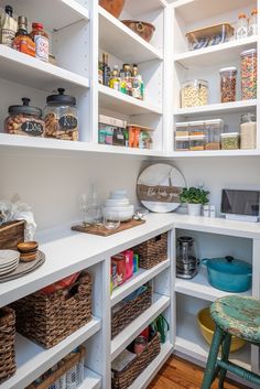 an organized pantry with white shelves and baskets