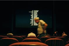 people sitting in an auditorium watching a movie