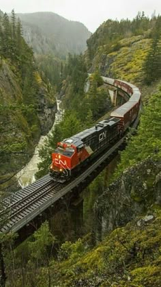 a train traveling over a bridge in the mountains