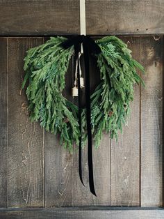 a wreath with bells hanging on a wooden wall