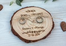 a wooden slice with two wedding rings tied to it