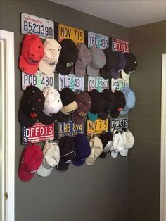 a bunch of hats are hanging on the wall in front of a door that is decorated with license plates