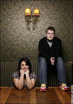 two people sitting on the floor in front of a wall