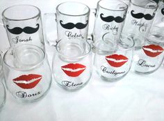 many glasses with lipstick and mustaches on them are sitting on a white tablecloth