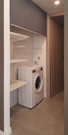 a washer and dryer are in the corner of a room with shelving